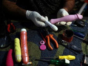 Bartolomeu Queiroz de Alencar, a toys repairman who became also a sex toys repairman, shows a vibrator engine in his workshop in Osasco, Brazil, August 7, 2019.