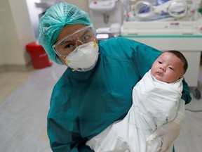 A nurse poses for a picture with a one-month-old Thai baby, the country's youngest coronavirus disease (COVID-19) patient that has successfully recovered, a day before being discharged from Bamrasnaradura Infectious Diseases Institute in Bangkok, Thailand April 22, 2020.