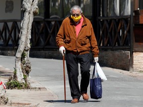 A man wearing a protective face mask and gloves is seen in Capri, as the spread of coronavirus disease (COVID-19) continues in Capri, Italy, April 24, 2020.