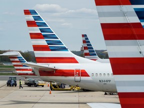 A member of a ground crew walks past American Airlines planes parked at the gate during the coronavirus disease (COVID-19) outbreak at Ronald Reagan National Airport in Washington, U.S., April 5, 2020.