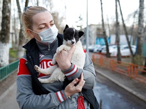 Volunteer Elena wearing a protective face mask carries Locky, a one-and-a-half month-old mongrel puppy, to its new home in Krasnogorsk outside Moscow, Russia April 29, 2020.