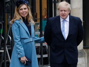 Britain's Prime Minister Boris Johnson with his partner Carrie Symonds leave after attending the annual Commonwealth Service at Westminster Abbey in London on March 09, 2020.