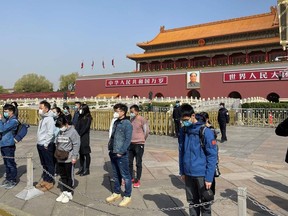 People bow in front of Tiananmen Gate in Beijing during a three minute national memorial to commemorate people who died in the COVID-19 coronavirus outbreak, on April 4, 2020.