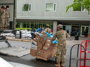 In this U.S. Army photo, Georgia Army National Guardsmen with the Marietta-based, 78th Troop Command, distribute breakfast and lunch meals to students and families at Douglass High School, Atlanta, April 20, 2020.