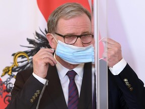 Austrian Secretary General of the Economic Chamber (WKÖ) Karlheinz Kopf puts a mask on during a press conference on the protection for groups at risk amid the new coronavirus COVID-19 pandemic, on April 21, 2020 in Vienna.