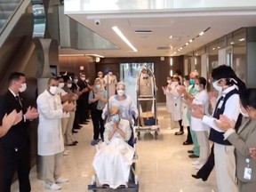 Health workers applaud as a recovered 97-year-old lady is discharged from a hospital in Sao Paulo, Brazil, April 12, 2020 in this screen grab taken from social media video. (Rere D'or Sao Luiz via REUTERS)