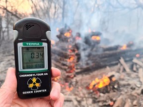A geiger counter measures radiation level at a site of fire burning in the exclusion zone around the Chernobyl nuclear power plant, outside the village of Rahivka, Ukraine April 5, 2020. (REUTERS/Yaroslav Yemelianenko)