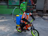 A chimp rides a bicycle sanitizing the facility at Samutprakarn Crocodile Farm and Zoo near Bangkok.