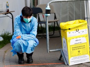A medical worker waits to test people for COVID-19 outside the intensive care unit of a hospital, during the lockdown imposed by the Belgian government, in Brussels, Belgium Friday, April 17, 2020.