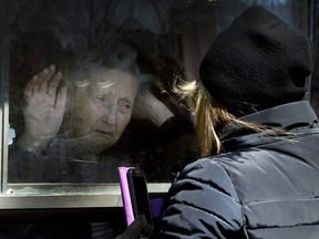 Diane Colangelo visits her 86-year-old mother Patricia through a window at Orchard Villa long-term care home in Pickering on Wednesday, April 22, 2020..