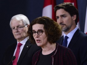 Deputy Minister of Foreign Affairs Marta Morgan speaks as Minister of Transport Marc Garneau, left, and Prime Minister Justin Trudeau, right, look on as they hold a press conference at the National Press Theatre in Ottawa on Wednesday, Jan. 8, 2020. Canada's deputy minister of foreign affairs has tested positive for COVID-19. Marta Morgan has been the top official in the department for just under a year, after leading the Immigration Department.