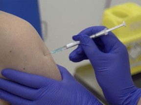 A screen grab taken from a video issued by Britain's Oxford University shows a person being injected as part of the first human trials in the United Kingdom to test a potential coronavirus vaccine, by Oxford University in England, Thursday April 23, 2020.