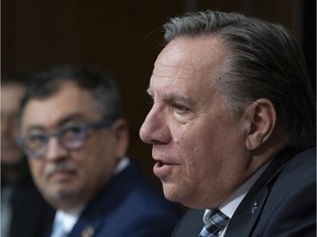 Quebec Premier Francois Legault speaks to reporters during a news conference on the COVID-19 pandemic on Friday, April 24, 2020, at the legislature in Quebec City. Horacio Arruda, Quebec director of public health, looks on.