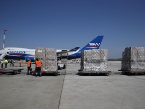 Workers unload a cargo plane at Eleftherios Venizelos International Airport in Athens, Tuesday, March 31, 2020.