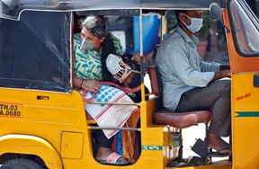 A dog wearing a protective mask is seen with its owner inside an autorickshaw during a 21-day nationwide lockdown to limit the spreading of the COVID-19 coronavirus in Chennai, India, March 30, 2020.