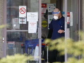 A man exits Eatonville Care Centre on The East Mall in Toronto with a Life Labs specimen bag on Tuesday, April 14, 2020.