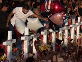 People pray and pay their respects at the makeshift memorial for victims of the shooting at the Cielo Vista Mall WalMart  in El Paso, Texas, on August 6, 2019.