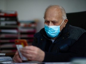 French doctor Christian Chenay, 98, wearing a protective face mask, sits in his consulting room at the doctor's office in Chevilly-Larue near Paris April 14, 2020.