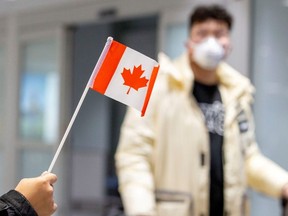 A traveller wears a mask at Pearson airport arrivals, shortly after Toronto Public Health received notification of Canada's first presumptive confirmed case of novel coronavirus, in Toronto, Ontario, Canada January 26, 2020.