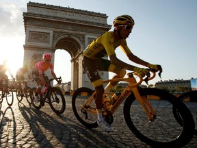 Team INEOS rider Egan Bernal of Colombia, wearing the overall leader's yellow jersey, in action in front of the Arc de Triomphe.
