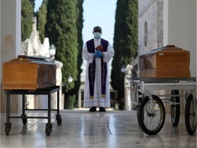Coffins of two victims of coronavirus disease (COVID-19) are seen during a burial ceremony in the southern town of Cisternino, Italy March 30, 2020. (REUTERS/Alessandro Garofalo)