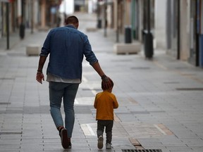 A man and his son take a walk in the empty La Bola street, after restrictions were partially lifted for children for the first time in six weeks, during the coronavirus disease (COVID-19) outbreak in Ronda, Spain, April 26, 2020.