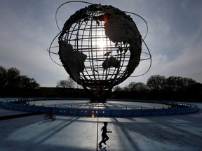 A child plays under The Unisphere in Flushing Meadows-Corona Park during the outbreak of the coronavirus disease (COVID-19) in the Queens borough of New York City, U.S., April 25, 2020.