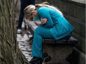 A healthcare worker sits on a bench near Central park in the Manhattan borough of New York City,  March 30, 2020. (REUTERS/Jeenah Moon)