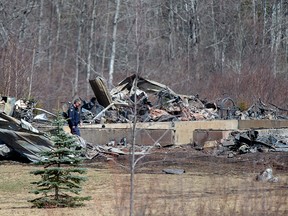 An RCMP investigator inspects a house destroyed by fire at the residence of Alanna Jenkins and Sean McLean, both corrections officers, in Wentworth Centre, N.S. on Monday, April 20, 2020. A neighbour, Tom Bagley, was also killed on the property.