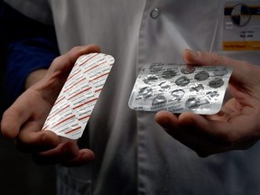 In this file photo taken on February 26, 2020 a medical officer shows packets of a Nivaquine, tablets containing chloroquine and Plaqueril, tablets containing hydroxychloroquine.
