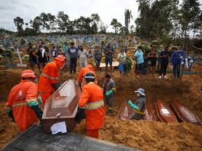 Gravediggers carry a coffin during a collective burial of people that have passed away due to COVID-19, at the Parque Taruma cemetery in Manaus, Brazil April 28, 2020.