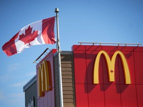 The Canadian flag flutters in the wind outside a McDonald's restaurant in London, Ont., on Sept. 30, 2019.