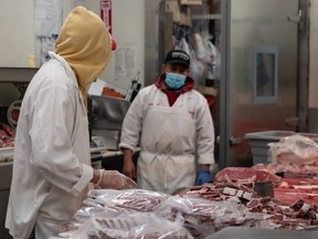 A butcher processes some meat at Vincent's Meat Market in the Bronx borough of New York City, April 17, 2020.