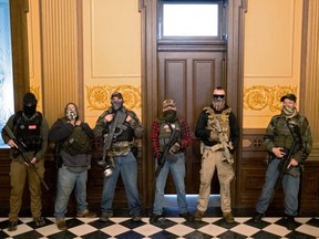 A militia group with no political affiliation from Michigan stands in front of the Governor's office after protesters occupied the state capitol building during a vote to approve the extension of Governor Gretchen Whitmer's emergency declaration/stay-at-home order due to COVID-19, at the state capitol in Lansing, Michigan, Thursday, April 30, 2020.