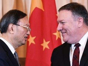 In this file photo taken on Nov. 9, 2018, U.S. Secretary of State Mike Pompeo and Chinese politburo member Yang Jiechi shake hands following a press conference during the U.S.-China Diplomatic and Security Dialogue, in the Benjamin Franklin Room of the State Department in Washington, D.C.