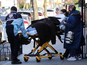 Health workers carry a patient to an ambulance on April 11, 2020 in the Brooklyn borough of New York.
