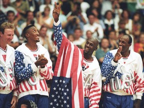 U.S. basketball player Michael Jordan (second from right) flashes a victory sign as he stands with team mates Larry Bird (left), Scottie Pippen and Clyde Drexler (right), nicknamed the Dream Team after winning the Olympic gold in Barcelona, Spain August 8, 1992.