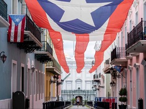 A man walks a dog in front of the Governor's mansion in Old San Juan, Puerto Rico on April 7, 2020.