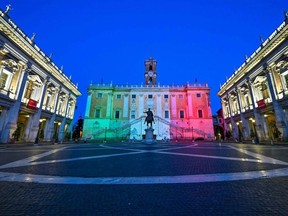 The colours of the Italian flag are projected onto the Palazzo Senatorio building on Capitoline Hill in Rome, Sunday, April 26, 2020.