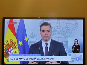 Spanish Prime Minister Pedro Sanchez is seen on a television screen during a live news conference, during a lockdown amid the coronavirus disease (COVID-19) outbreak, in Ronda, southern Spain, April 25, 2020.