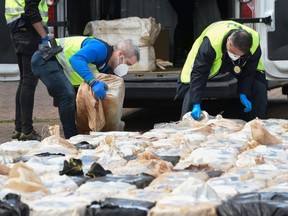 Spanish policemen check packs of cocaine in the port of Vigo, on April 28, 2020, after seizing the vessel MV Karar carrying 4,000 kg of cocaine, amid a national lockdown to fight the spread of the COVID-19.