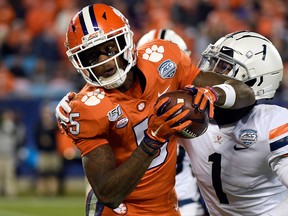In this Dec. 7, 2019, file photo, Clemson wide receiver Tee Higgins catches a pass while Virginia cornerback Nick Grant defends during the second half of the Atlantic Coast Conference championship NCAA college football game in Charlotte, N.C.
