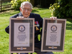 Britain's Captain Tom, 99, poses with two world records for fundraising walk and song for the National Health Service in Marston Moretaine, Bedfordshire, Britain, on April 23, 2020.