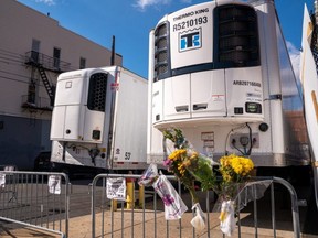 Flowers left by the community are placed near to the morgue refrigerated trailers at the Wyckoff Heights Medical Center, in the Brooklyn borough of New York City, on Wednesday, April 22, 2020.