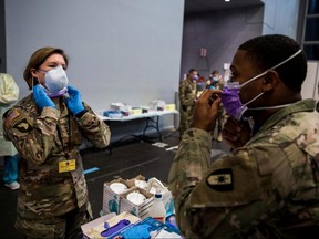 Army Lieutentant General Laura Richardson, commanding general of U.S. Army North, puts on personal protective equipment before entering the patient care area at Javits New York Medical Station, which is supporting local hospitals treating COVID-19 in New York City, Sunday, April 12, 2020.
