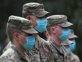 Florida National Guard members wear protective masks as Gov. Ron DeSantis gives updates on the state's continued response to the coronavirus pandemic during a press conference in Fort Lauderdale, Friday, April 17, 2020.