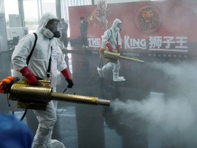 Volunteers from the Blue Sky Rescue team disinfect the Qintai Grand Theatre in Wuhan, the epicentre of China's coronavirus outbreak, April 2, 2020. (REUTERS/Aly Song)