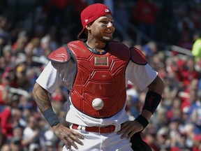 St. Louis Cardinals catcher Yadier Molina stands with his hands on his hips as a ball is somehow stuck to his chest protector during a game against the Chicago Cubs on Thursday, April 6, 2017.