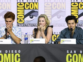 KJ Apa, left, Lili Reinhart, and Cole Sprouse speak at the "Riverdale" Special Video Presentation and Q&A during 2019 Comic-Con International at San Diego Convention Center on July 21, 2019 in San Diego, Calif.