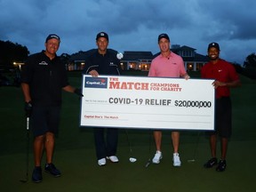 Tiger Woods and former NFL player Peyton Manning celebrate defeating Phil Mickelson and NFL player Tom Brady of the Tampa Bay Buccaneers on the 18th green during The Match: Champions For Charity at Medalist Golf Club in Hobe Sound, Fla., Sunday, May 24, 2020.